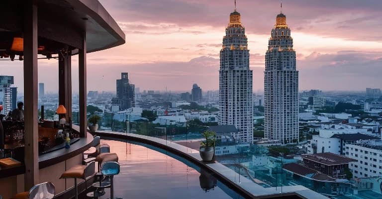 Rooftop pool overlooking Bangkok skyline at sunset