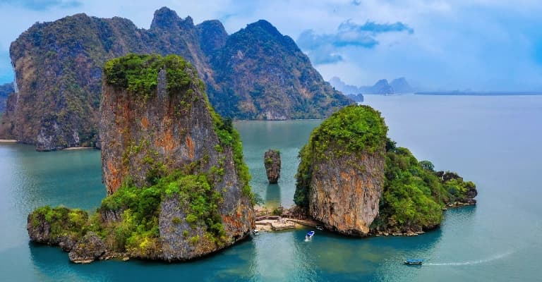 A longtail boat over turquoise water near a Thai island