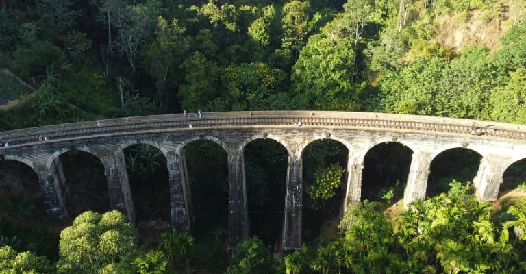 Nine Arch Bridge in Ella surrounded by lush forest and scenic railway track