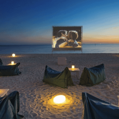 Private beachfront cinema set up on the sand at night in Phuket, Thailand