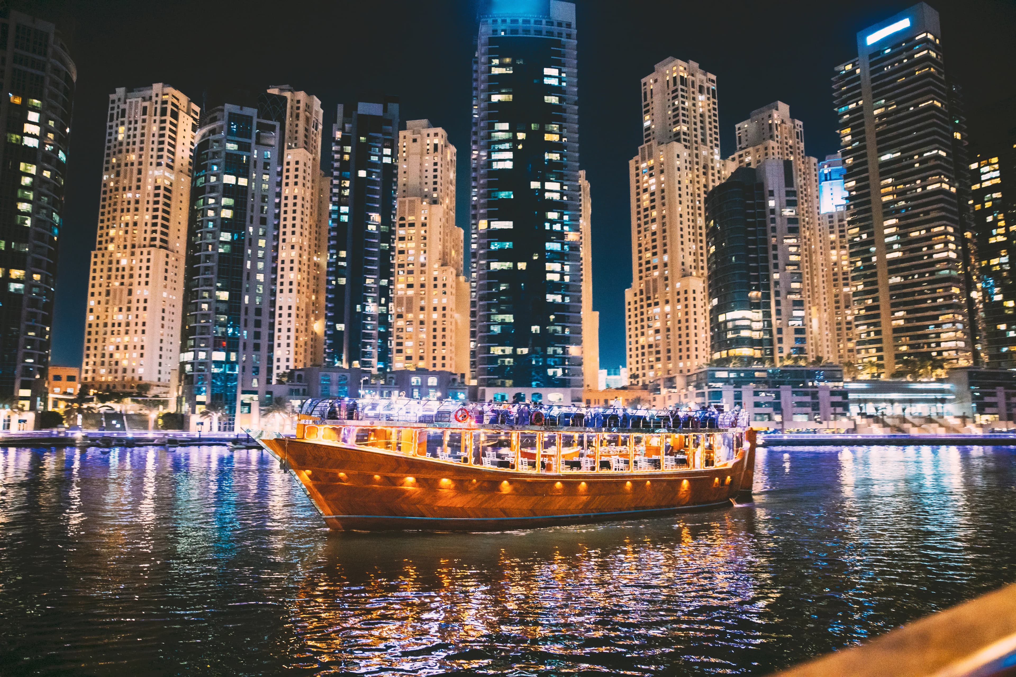 Traditional dhow cruise in Dubai Marina with illuminated skyline at night